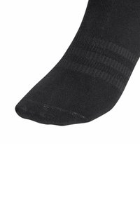 Czarna skarpeta na kostkę o prążkowanej fakturze i wzmocnionej strefie palców, noszona na stopie skierowanej w dół na białym tle.