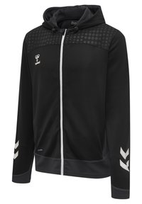 Felpa nera con zip e cappuccio con coulisse, motivo a pois sulle spalle, logo hummel bianco sul petto e strisce bianche a chevron sulle maniche.
