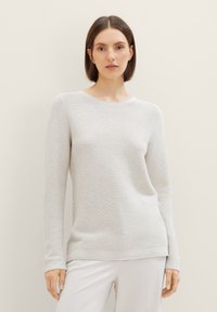 Pull en maille côtelée gris clair à manches longues, col rond et coupe décontractée. Texture douce et subtiles rayures horizontales.