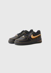 Mustad nahast spordijalatsid oranžide õmbluste ja aktsentidega. Omab ümarat nina, pehmendatud kaelust ja tekstuurset kummist tallat. Nike logo on kohal.