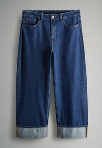 Tumšas džinsa bikses ar brīvu piegriezumu, ar ruļļveida kājām, piecas kabatas un zelta šuvju akcentiem. Gluda tekstūra, taisnas kājas dizains.