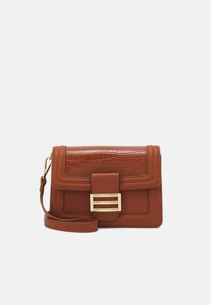 Sac bandoulière en cuir marron avec rabat à texture crocodile, boucle rectangulaire dorée et sangle réglable sur fond neutre.