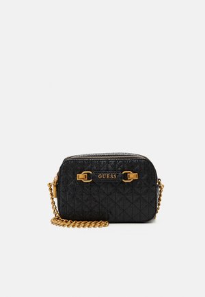 Sort quiltet crossbody taske med guldkæde rem og "GUESS" logo plade på fronten, lynlås lukning på toppen.