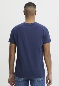 Marineblå bomull T-skjorte med rund hals, kort erm og en enkel design. Bakview viser en jevn tekstur og minimal detaljering.