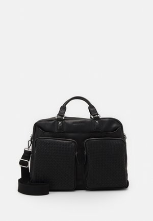 Bolso de piel negra con textura trenzada, bolsillos frontales, asas superiores dobles, correa de hombro ajustable y acentos de hardware en plata.