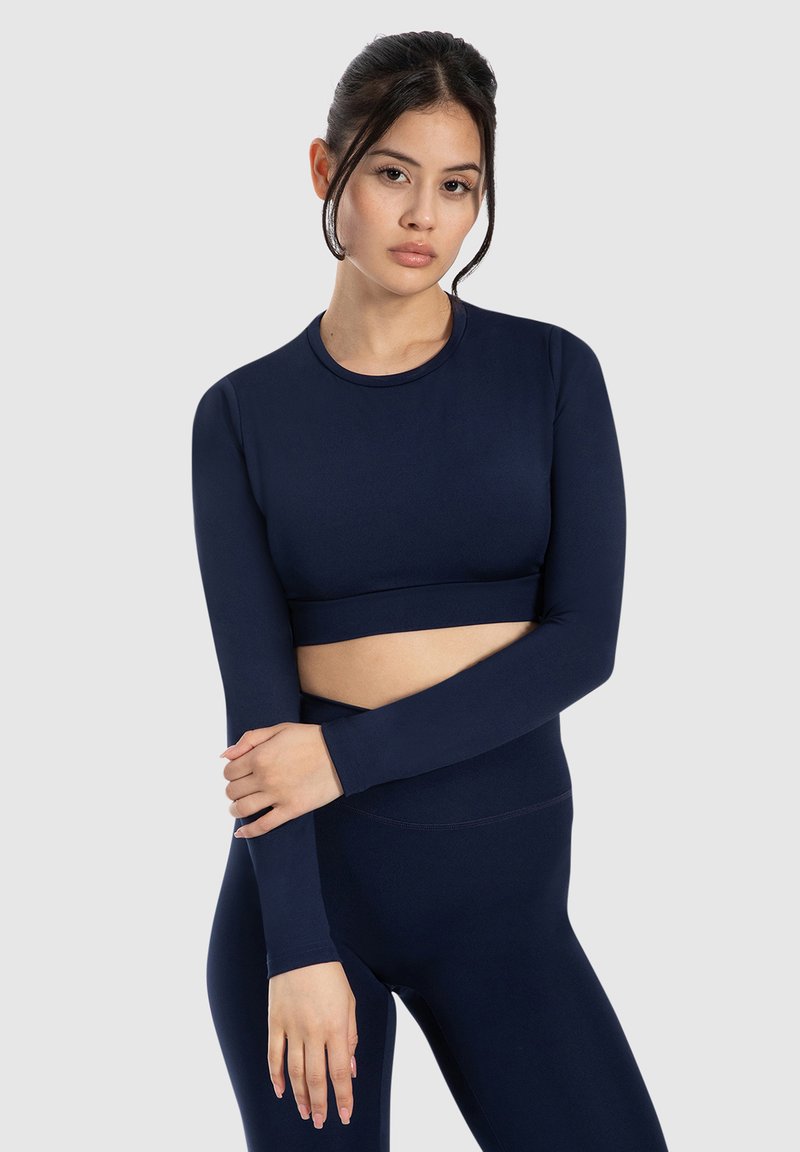 Top corto a maniche lunghe navy in materiale elasticizzato con scollatura rotonda e design aderente, abbinato a leggings high-waisted coordinati.