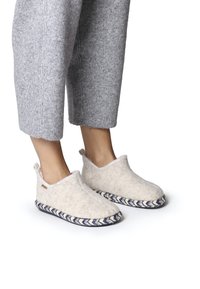 Slipperi od filca boje kreme s pletenim plavim đonom, koji imaju glatku teksturu i mekane gornje rubove za udobnost.