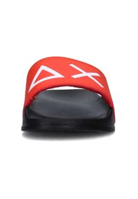 Infradito rossi con una fascia larga caratterizzata da grafiche bianche del logo, una soletta nera texturizzata e un design a suola piatta.