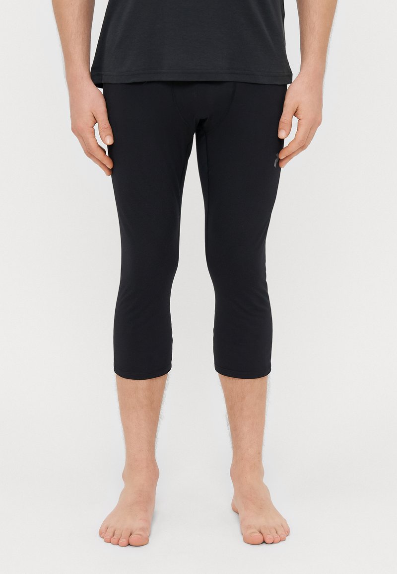 Black capri leggings made of smooth, stretchy material, featuring a snug fit that ends below the knee and a small logo detail on the side.