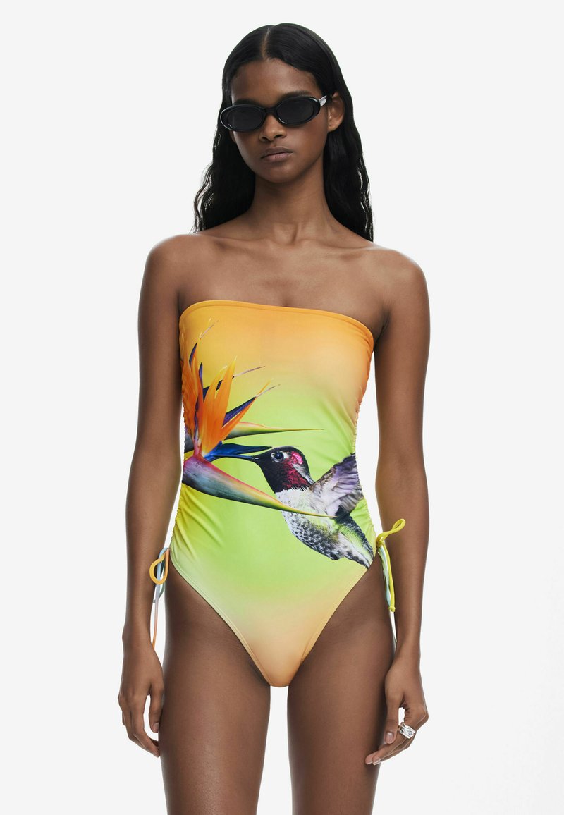 Costum de baie fără bretele în degrade de portocaliu către verde, având un imprimeu vibrant cu o colibrie și o floare paradis. Cordețele laterale pentru ajustare.