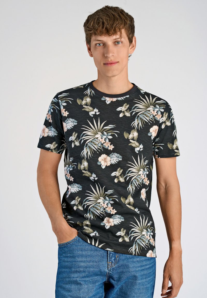 Musta lyhythihainen t-paita, jossa on värikäs kukkakuosi vihreillä lehdillä ja vaaleanpunaisilla kukilla, valmistettu pehmeästä kankaasta ja jossa on pyöreä kaula-aukko.