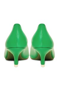 Gröna läderpumps med spetsig tå och smal klack. Slät textur och sömlös design, med en enfärgad yta utan mönster.
