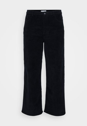 Pantalones de pana en negro, con un diseño de pierna recta, bolsillos frontales, cierre de botón y cremallera, y un acabado suave y texturizado.