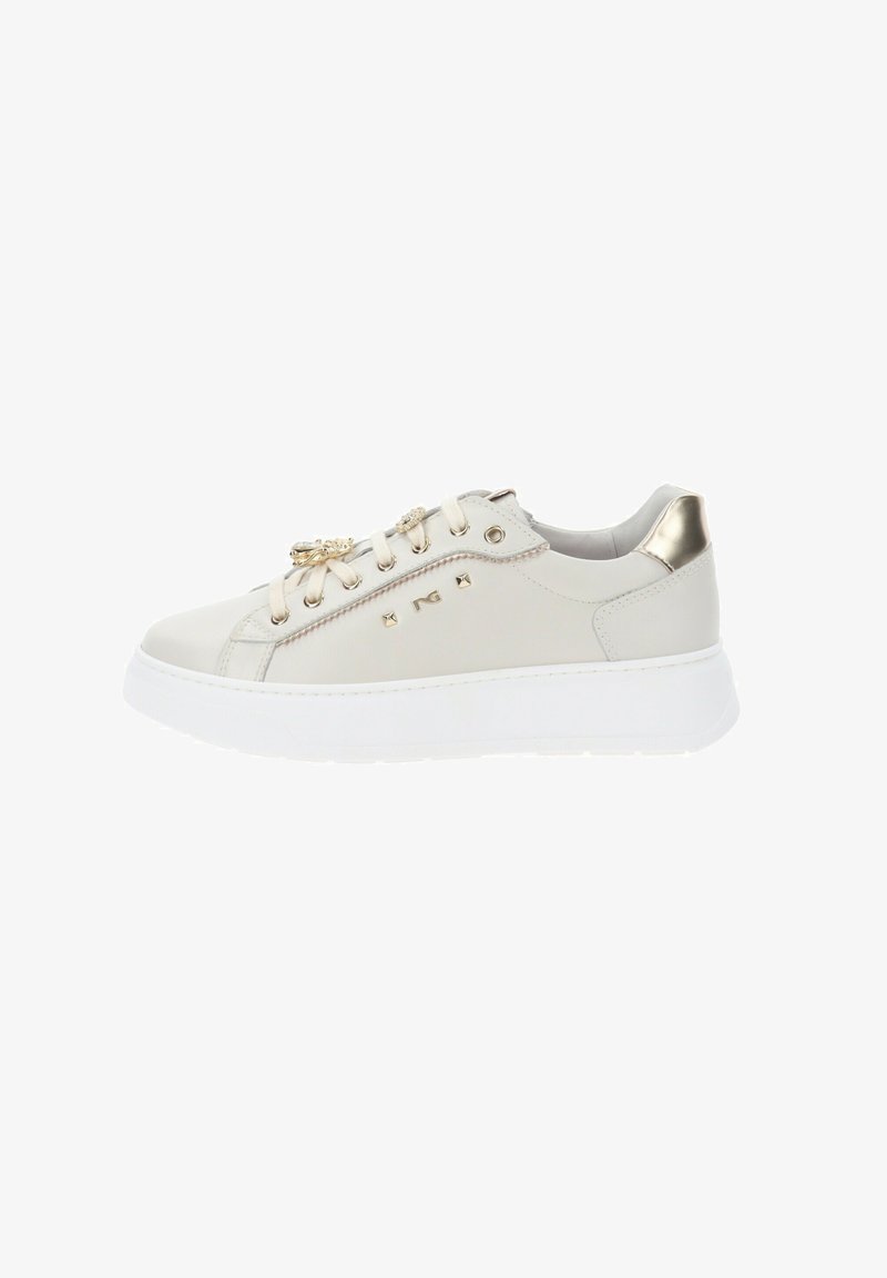 Zapatillas de cuero beige con detalles dorados, suela de goma blanca plana, tachuelas decorativas y diseño con cordones.