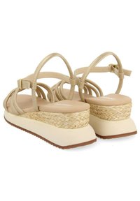 Sandalias de plataforma beige con diseño de tiras entrelazadas, que cuentan con una plantilla de yute trenzado y una suela de goma suave. Tira de tobillo ajustable.