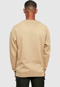 Merchcode THINK DIFFERENT - Sweatshirt - unionbeige