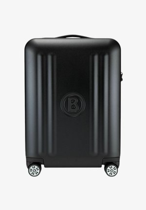 Zwarte harde koffer met verticale ribbels, een rond logo en vier multidirectionele wielen voor gemakkelijke mobiliteit.