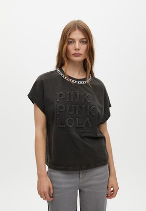 T-shirt corto grigio scuro con testo in rilievo "PINK PUNK LOLA" e bordo decorativo simile a una collana sul colletto. Vestibilità casual, texture morbida.