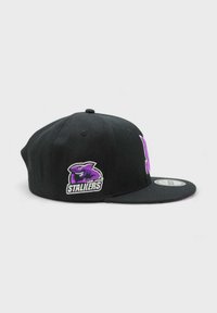 Musta lippalakki tasaisella lierillä. Edessä on violetti ja valkoinen brodeerattu logo "San Jose Stallions". Rakenne on jämäkkä ja materiaali on puuvillaa.