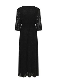 Fekete maxi ruha áttetsző borítással, virágmintával, rugalmas derékkal és háromnegyedes ujjal. Az anyag könnyűnek és áramlónak tűnik.