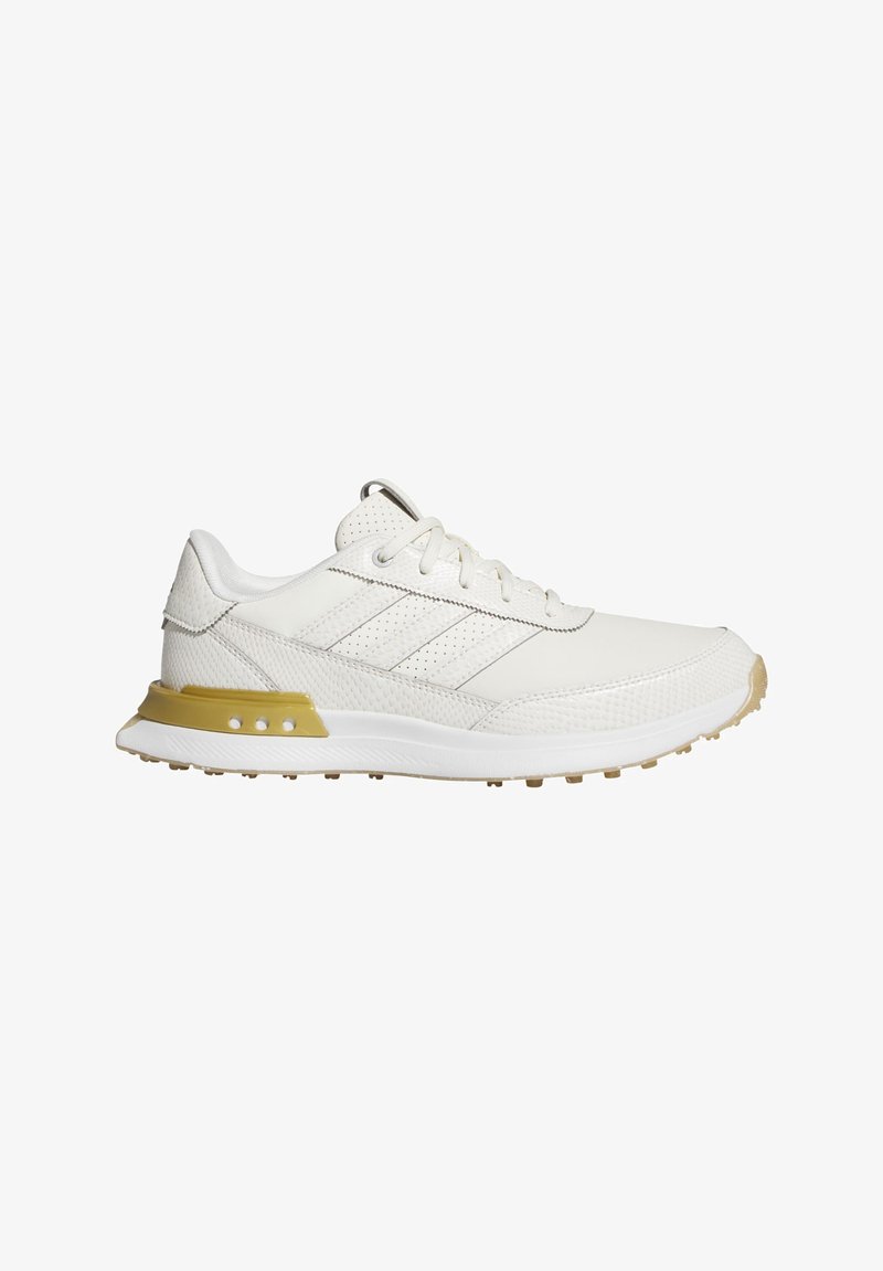 White athletic shoes with textured overlays, featuring three diagonal stripes, a beige accent on the heel, and a patterned outsole for traction.