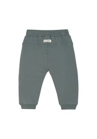 Ljust gröna sweatpants gjorda av mjukt tyg, med elastisk midja och ribbade manschetter. Inga fickor, enkel design, jämn textur.