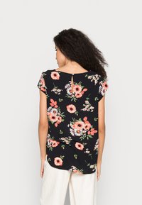 Top floral com mangas curtas, fundo preto, apresenta flores rosas e brancas, detalhe de recorte nas costas com botão, tecido leve.