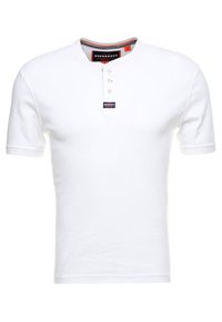 Bílé tričko s krátkým rukávem vyrobené z bavlny, s výstřihem Henley se třemi knoflíky, pleteným límcem a štítkem s logem Superdry.