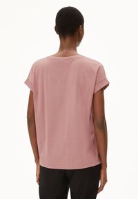 Kurzärmliges, locker sitzendes Oberteil aus einem weichen Baumwollmischgewebe in sanftem Pink, mit rundem Ausschnitt und hochgerollten Ärmelsäumen. Glatte Textur, lässiges Design.