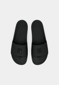 Sandale negre tip slip-on cu tălpi texturate și un breton lat care are un mic logo "HUGO" embosat pe fiecare breton.