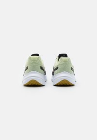 Chaussures de sport avec une tige en mesh noir, des accents vert clair, une semelle blanche rembourrée et une semelle extérieure en caoutchouc dotée d'un motif de traction.