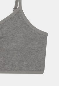 Grå bralette med en mjuk, slät yta, med en bred, bågformad halsringning och smala axelband. Kanterna är avslutade med en kontrasterande grå kant.