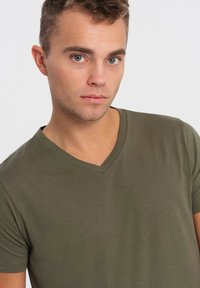 Olivengrøn v-hals t-shirt i blødt, glat stof med korte ærmer. Har en afslappet pasform og minimal stikning langs halsudskæringen.