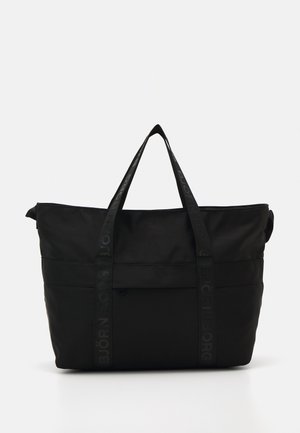 Saco de tecido preto com alças duplas na parte superior, apresentando uma textura suave e um logotipo em relevo nas alças; fecho em zip na parte superior.
