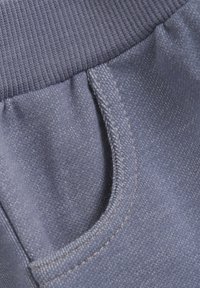 Blå joggingbyxor i bomullsmix med elastisk midja, framficka och kontrasterande söm. Strukturerad tyg med mjukt avslut.