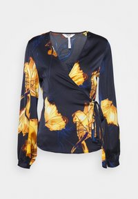 Wickelbluse aus navyblauem Stoff mit großen gelben Blumenmustern, langen Ärmeln mit gerafften Manschetten und seitlichem Bindeband.