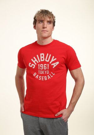 Red cotton T-shirt featuring a round neckline and short sleeves. Front design includes "SHIBUYA 1961 TOKYO BASEBALL" in white lettering.