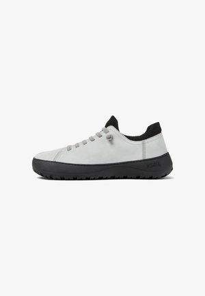 Light grey sneakers with a smooth suede upper, low-profile black rubber sole, and gray laces, featuring a black ribbed collar.