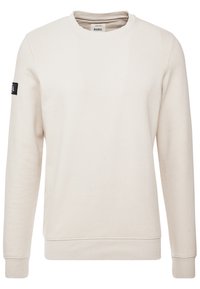 Sweat-shirt beige avec col rond, manches longues, poignets côtelés et un patch logo en tissu sur la manche gauche ; fabriqué en matière douce en mélange de coton.