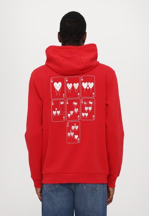 Red hoodie featuring a graphic of playing cards with heart designs printed in white on the back. Drawstring hood and pocket details.
