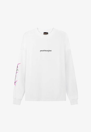 Biała koszula z długim rękawem z czarnym napisem "postcard from my heart." na środku z przodu oraz różowy kwiatowy wzór z czarnym napisem na lewym rękawie.