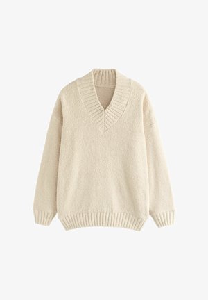Krém színű pulóver, V nyakkivágással, bordás gallérral és mandzsettákkal. Puha, texturált anyagból készült, laza fit és esett vállakkal.