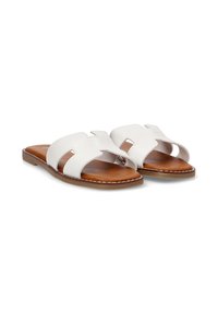 Sandalias deslizantes de cuero blanco con plantillas de imitación de cuero marrón, que cuentan con dos correas anchas y acentos troquelados. Suela plana con detalles de costura.