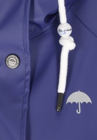 Námorná nepremokavá bunda s strieborným logom dáždnika, bielym sťahovacím šnúrkou s dekoratívnym korálikom a s logom značky na gombíku s emblémom stromu.