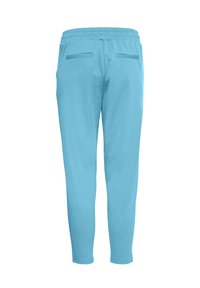 Lichtblauwe taper-fit sweatpants met elastische tailleband en twee horizontale achterzakken tegen een witte achtergrond.