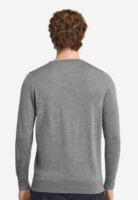 Grå långärmad tröja, gjord av ett mjukt stickat tyg. Har en ribbad halsringning, muddar och nederkant. Enkelt och klassiskt design.