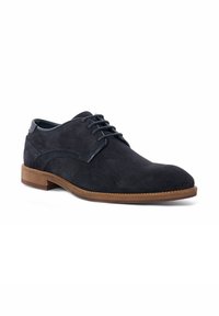 Dark gray suede lace-up shoe with a rounded toe, a smooth leather trim, and a brown rubber sole. Features minimalist design and stitching accents.