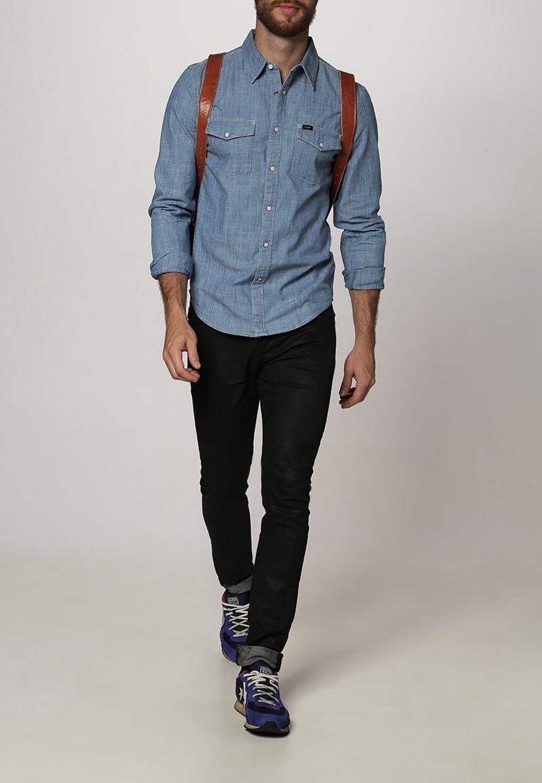 Vaaleansininen chambray-paitapusero, mustat slim fit -housut ja violetit urheilukengät. Ruskeat nahkaiset olkahihnat.