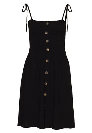 Black sleeveless sundress with smocked bodice, adjustable tie shoulder straps, and a front row of brown buttons from top to hem.