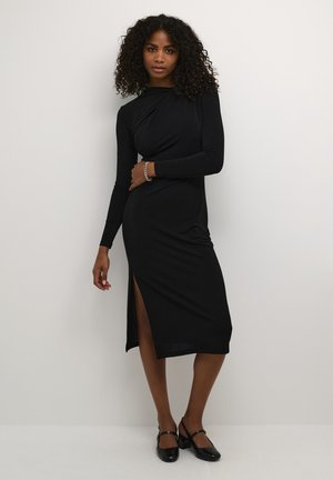 Black long-sleeve fitted dress with a side slit, made of smooth fabric, featuring a draped design at the neckline and a midi length.